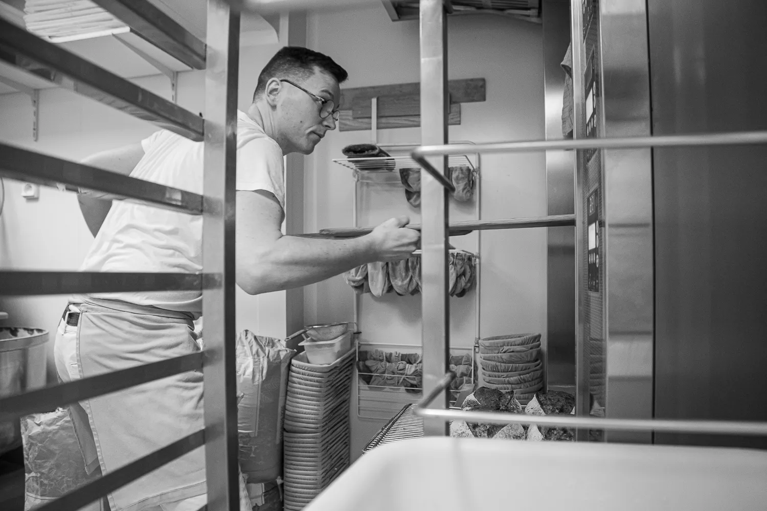 Boulanger devant les clayettes, en noir et blanc