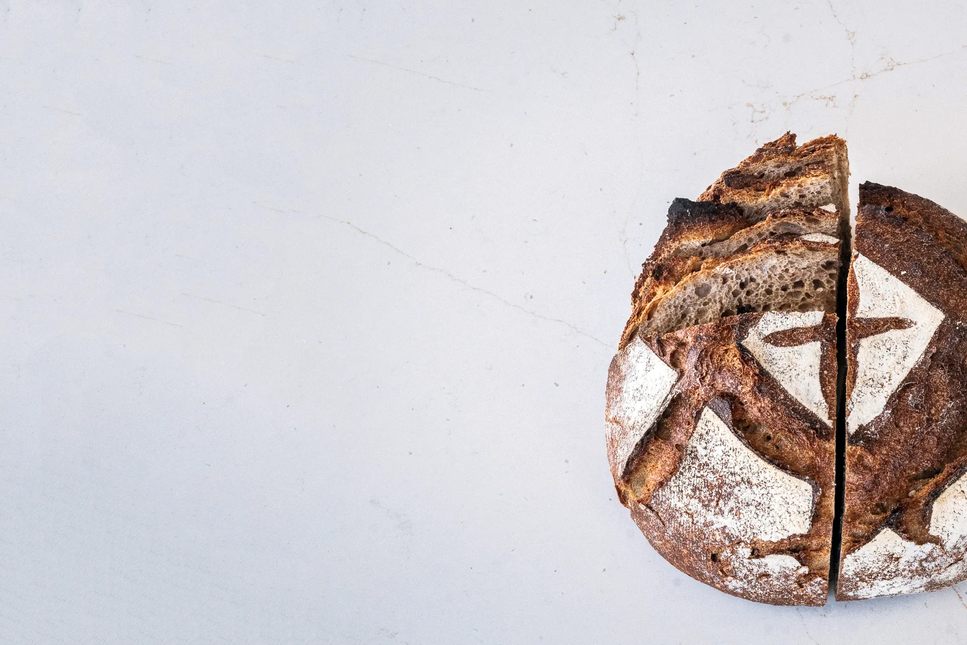 Pain au levain scarifié au motif de la maison, sur plan de travail