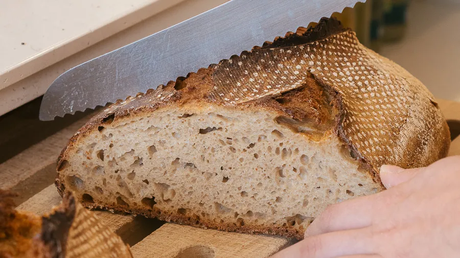 Miche de pain au levain tranchée, croûte foncée et mie alvéolée