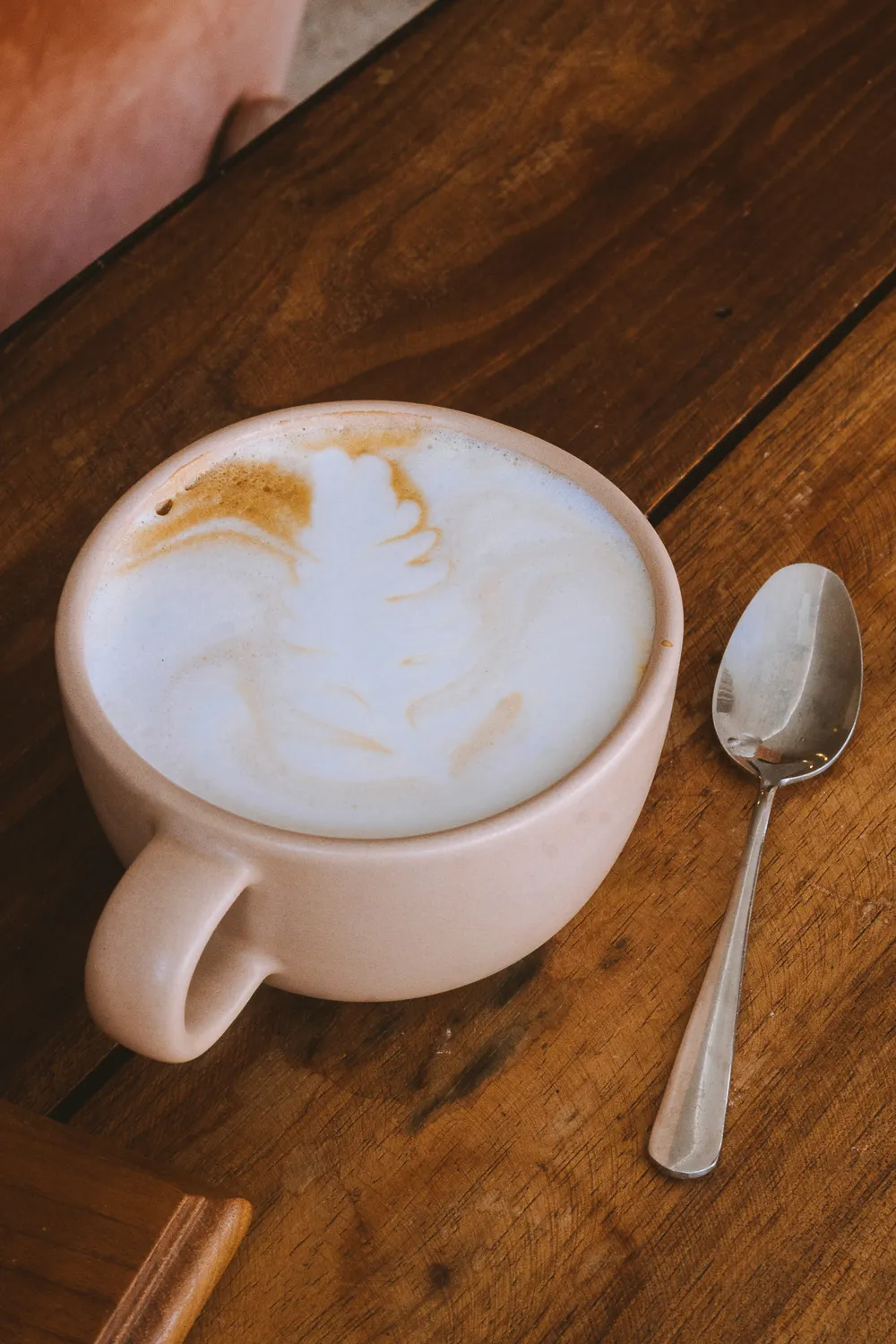 Cappuccino au lait mousseux sur une table en bois du salon de thé
