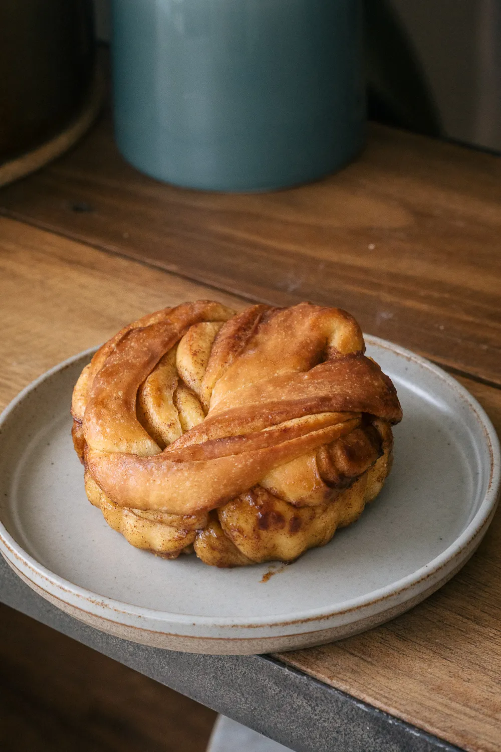 Brioche roulée à la cannelle sur une assiette en grès